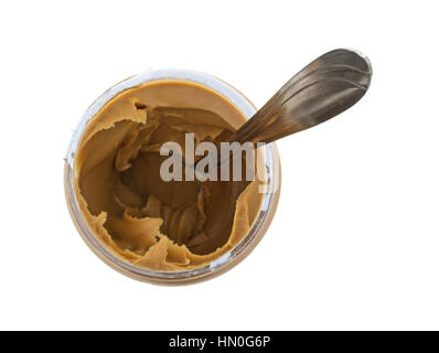 Vista superiore della apertura di un vasetto di crema di burro di arachidi con un cucchiaio nel cibo isolato su uno sfondo bianco. Foto Stock