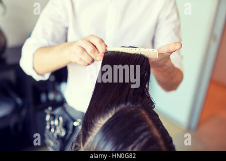 Stylist maschio mani di pettinatura dei capelli bagnati a salon Foto Stock