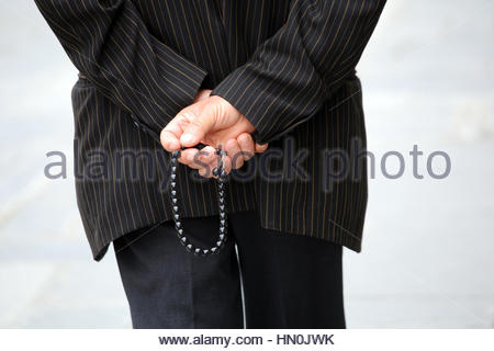 Un uomo vecchio con le mani in mano diteggiatura una preoccupazione di perline in preghiera o per passare il tempo in Grecia. Foto Stock