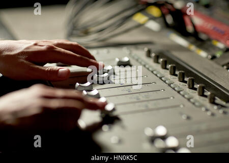 Mani sulla console di miscelazione in music studio di registrazione Foto Stock