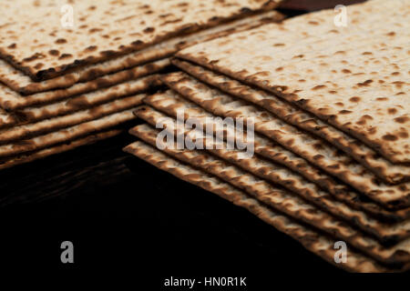 Tradizionale matzah ebraico su uno sfondo nero. Close-up Foto Stock