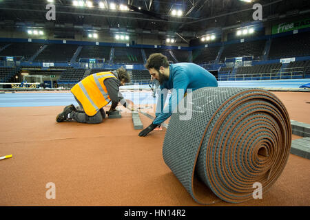 I lavoratori che stabilisce il nuovo infield via presso il National Indoor Arena di Birmingham prima di testare prima il Campionati mondiali Indoor nel 2018 Foto Stock