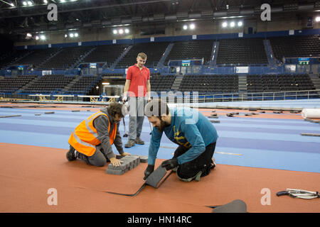 I lavoratori che stabilisce il nuovo infield via presso il National Indoor Arena di Birmingham prima di testare prima il Campionati mondiali Indoor nel 2018 Foto Stock