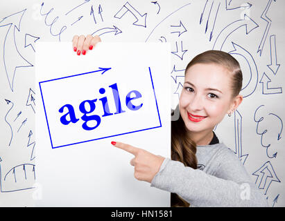 Giovane donna azienda lavagna con la scrittura parola: agile. Tecnologia, internet, business e marketing. Foto Stock