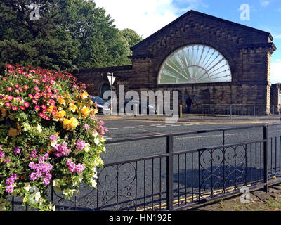 Rimanente parete in pietra con una ventola grande finestra del Vittoriano stazione Buxton, Buxton, Derbyshire, England, Regno Unito Foto Stock