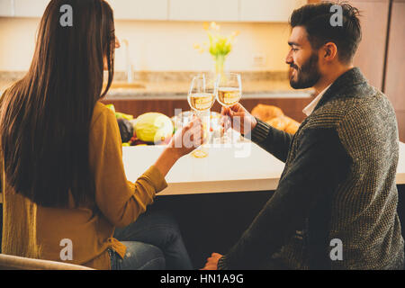 Coppia felice la tostatura con vino bianco nella cucina moderna Foto Stock