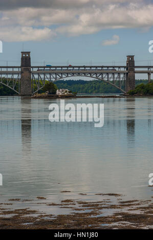 Treno che attraversa il Ponte Britannia (gallese: Pont Britannia) attraverso lo stretto di Menai tra l'isola di Anglesey e la terraferma del Galles. Foto Stock