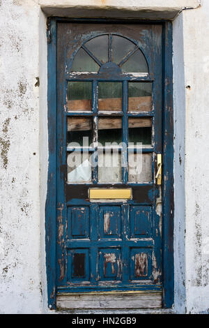 Porta con vernice rimossa in bisogno di pittura su una vecchia casa in Irlanda Foto Stock