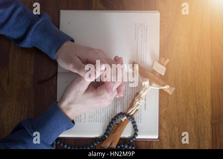 Mani a pregare con la Bibbia Foto Stock