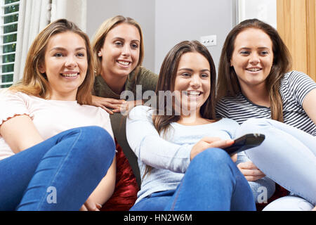 Un gruppo di ragazze adolescenti guardando la TV a casa insieme Foto Stock