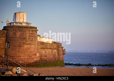 Liverpool Bay Golden Orange sunrise a New Brighton Fort Pesce persico Rock e la spiaggia al lungomare di Marine in Wallasey, Merseyside, Wirral, Inghilterra, Regno Unito. Foto Stock