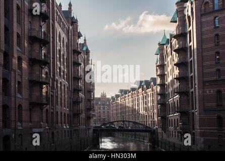 Edifici e canale nel vecchio magazzino district Speicherstadt di Amburgo, Germania Foto Stock