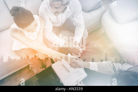 Imprenditrice facendo handshake con un imprenditore seduto sul divano in ufficio Foto Stock