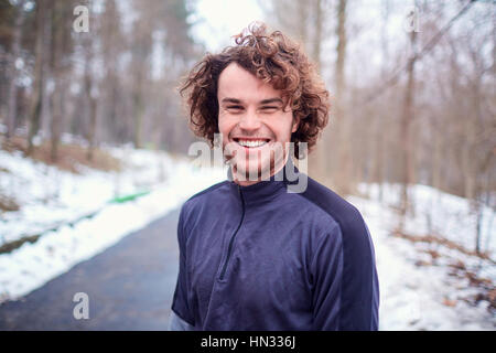 Giovane uomo sorridente ricci felice all'aperto in primavera, autunno closeup Foto Stock