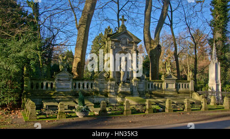 Grande vecchia famiglia tomba monumento wit statue di Gesù e gli angeli nel cimitero Melaten in un ambiente di verde su una soleggiata giornata invernale Foto Stock