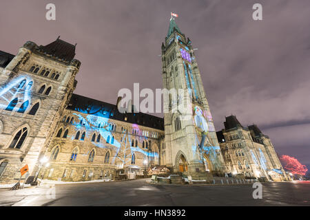 Vacanze inverno spettacolo luminoso proiettato durante la notte sulla Casa canadese del Parlamento per celebrare il centocinquantesimo anniversario del Canada di Ottawa in Canada. Foto Stock