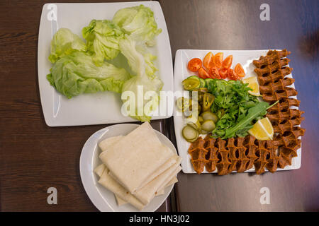 Bagno turco cigkofte piatto con lattuga, pomodoro, limone, prezzemolo e lavash Foto Stock