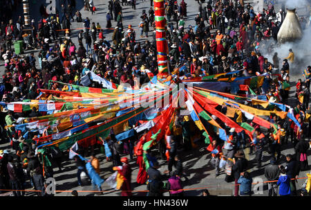 (170208) -- LHASA, 8 febbraio 2017 (Xinhua) -- devoti appendere bandiere di preghiera ad un palo vicino il tempio del Jokhang a Lhasa, capitale del sud-ovest della Cina di regione autonoma del Tibet, Febbraio 8, 2017. Come il periodo del nuovo anno tibetano si avvicina, bandiere di preghiera legata a cinque poli che circonda il tempio del Jokhang sono state sostituite da quelle nuove in conformità con la tradizione tibetana. (Xinhua/Chogo) (lb) Foto Stock