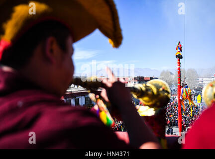 (170208) -- LHASA, 8 febbraio 2017 (Xinhua) -- Monaci eseguire la cerimonia religiosa in corrispondenza di un polo vicino il tempio del Jokhang a Lhasa, capitale del sud-ovest della Cina di regione autonoma del Tibet, Febbraio 8, 2017. Come il periodo del nuovo anno tibetano si avvicina, bandiere di preghiera legata a cinque poli che circonda il tempio del Jokhang sono state sostituite da quelle nuove in conformità con la tradizione tibetana. (Xinhua/Purbu Zhaxi) (lb) Foto Stock