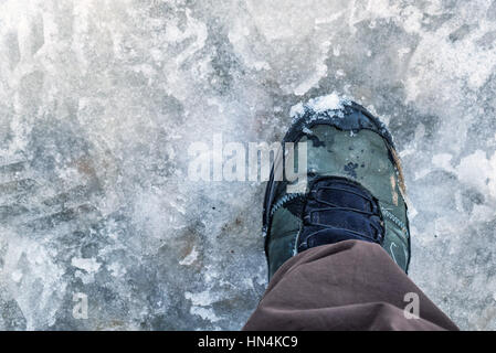 Prospettiva in prima persona di escursionismo boot nella neve e granite Foto Stock