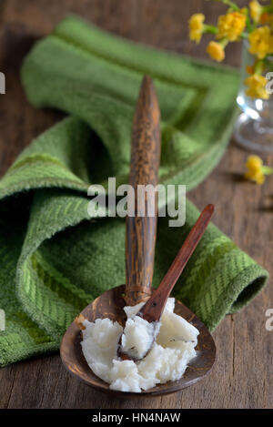 Olio di noce di cocco sul cucchiaio di legno Foto Stock