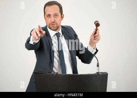 Un banditore maschio in azione di foratura di un martello durante un live auction. Foto Stock