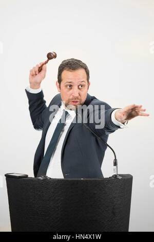 Un banditore maschio in azione di foratura di un martello durante un live auction. Foto Stock