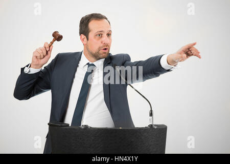 Un banditore maschio in azione di foratura di un martello durante un live auction. Foto Stock