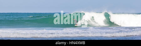 St Ives, Regno Unito - 11 Settembre 2011: un unico surfer le catture di una grande onda che rompe su Porthmeor Beach di St Ives, Cornwall. Il insolitamente Foto Stock