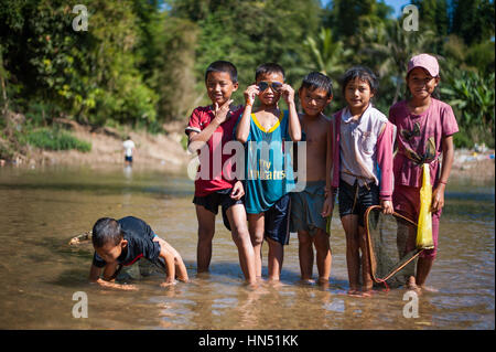 Un gruppo di bambini in Laos in posa di un piccolo ruscello Foto Stock