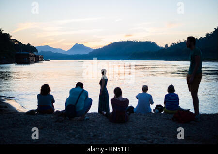 Persone godersi il tramonto sul fiume Mekong a Luang Prabang, Laos Foto Stock