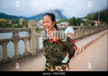 La donna che porta un bambino sulla schiena, Laos Foto Stock