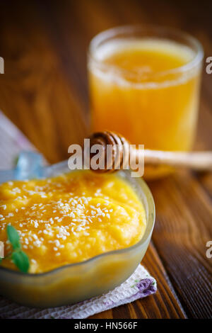 Zucca dolce porridge con il miele e i semi di sesamo al buio su un tavolo Foto Stock
