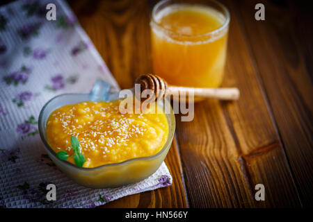 Zucca dolce porridge con il miele e i semi di sesamo al buio su un tavolo Foto Stock
