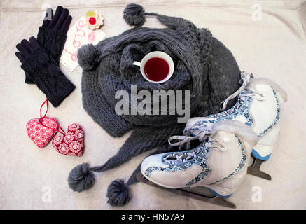 Bianco-blu di figura pattini, Warm Grey skarf con pompons), tazza di tè, guanti a maglia e carino cuori tessili Foto Stock