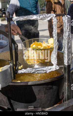 Macchina rendendo le patatine o patate fritte al Fiesta de matanza, celebrazioni annuali in Ardales.Andalusia, Spagna Foto Stock