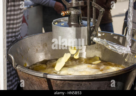 Macchina rendendo le patatine o patate fritte al Fiesta de matanza, celebrazioni annuali in Ardales.Andalusia, Spagna Foto Stock