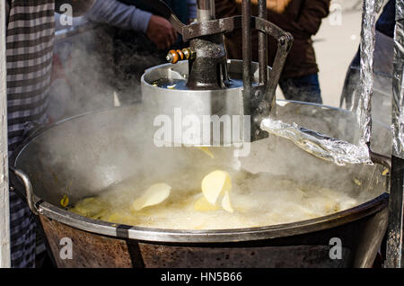 Macchina rendendo le patatine o patate fritte al Fiesta de matanza, celebrazioni annuali in Ardales.Andalusia, Spagna Foto Stock