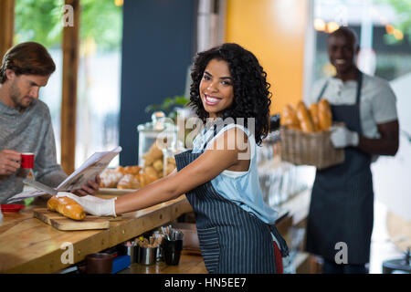 Ritratto di sorridente cameriera serve a contrastare in cafÃƒÂ© Foto Stock