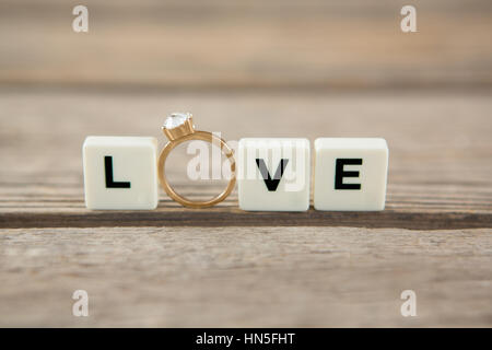 Anello diamante tra blocchi di bianco visualizzando il messaggio di amore su sfondo bianco Foto Stock