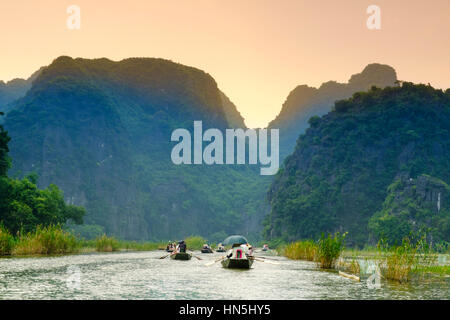 Le imbarcazioni turistiche sul fiume carsico nel paese in Tam Coc, Ninh Binh, Vietnam del Nord Foto Stock