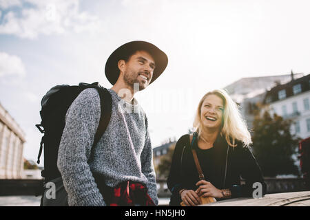 Giovane uomo e donna su una vacanza. Sorridente giovane uomo che porta uno zaino in piedi lungo con una signora. Foto Stock