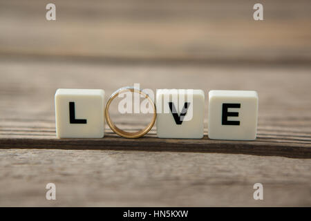 Anello diamante tra blocchi di bianco visualizzando il messaggio di amore su sfondo bianco Foto Stock