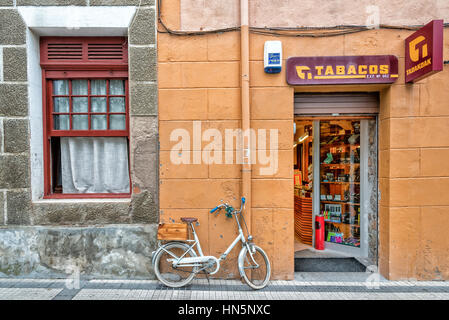 Una bicicletta parcheggiata al di fuori di un negozio di tabacchi in Picos de Europa Spagna Foto Stock