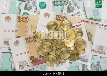 Su casualmente disperse banconote di rubli russi è un mazzetto di dieci-coin Foto Stock