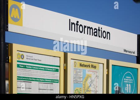 Cielo blu in una giornata di sole Merseyrail commuter rail rete M logo informazioni sul calendario e schede di segno della stazione in Wallasey, Merseyside, Wirral, Eng Foto Stock