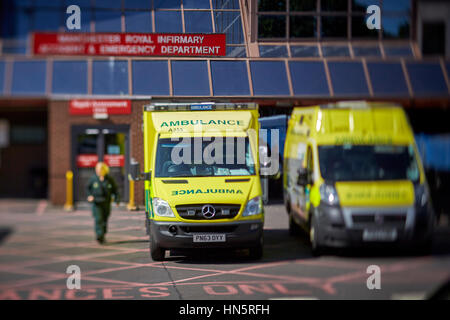 Liveried ambulanze parcheggiate sul dazio in alloggiamenti designato a Manchester Royal Infirmary England Regno Unito incidente e dipartimento di emergenza Foto Stock