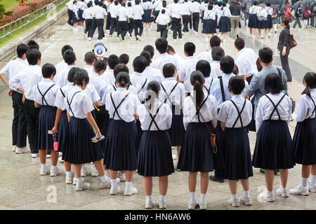 Nara, Giappone - 9 Maggio 2012: un grande gruppo di scuola giapponese di bambini in uniformi e una guida con un forte megafono su un viaggio scolastico di Tempio di Todai-ji in Foto Stock