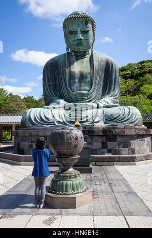 KAMAKURA, Giappone - 23 maggio : Una donna prega nella parte anteriore del Daibutsu Grande Buddha a Kotoku-nel tempio di Kamakura, Giappone il 23 maggio 2012. Il bronzo Bud Foto Stock