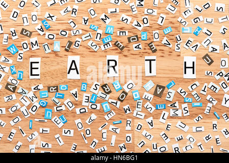 Parola di terra da tagliare le lettere sul tavolo di legno Foto Stock